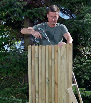 To vægsektioner skrues sammen Der bores foroven på udendørs bruser, inden de to vægsektioner skrues sammen